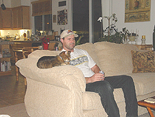 Dave and Allie relax on the couch with a beer.