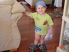 Hunter wearing his dinosaur slippers along with his Speedo cap.