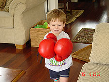 Hunter wearing daddy's boxing gloves.