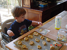 Hunter putting M&Ms on the cookies.