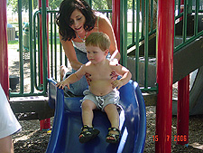 Ashlee helps Hunter go down the slide by himself.